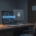 A professional, realistic illustration in a modern editorial style showing a dimly lit office at night. On a wooden desk sits an open laptop displaying an email inbox with a mix of business messages (subject lines about suppliers, invoices, and customer inquiries) and a few clearly private ones (marked subtly with family icons). A semi-transparent overlay of a locked padlock and faint privacy barrier hovers over the private emails, while business-related messages glow softly in blue. In the background, a closed office door with a "sick leave" sign and an empty chair convey absence. The color palette is cool blues, grays, and warm amber from a desk lamp, creating a tense yet balanced atmosphere between business necessity and data privacy. No text, logos, or people are visible. Cinematic lighting, clean composition, high detail.